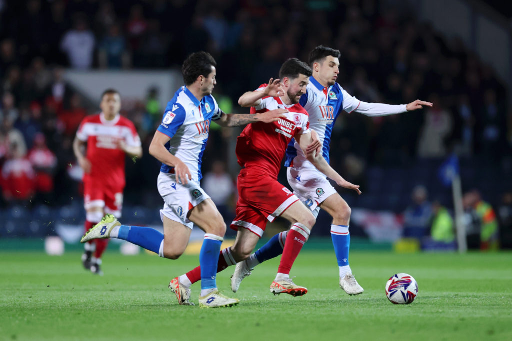 Finn Azaz of Middlesbrough runs with the ball under pressure from John Buckley and Lewis Travis of Blackburn Rovers