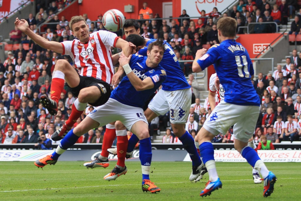 Jos Hooiveld (L) of Southampton heads narrowly wide as Greg Halford (2L) of Portsmouth challenges during the npower Championship match between Southampton and Portsmouth
