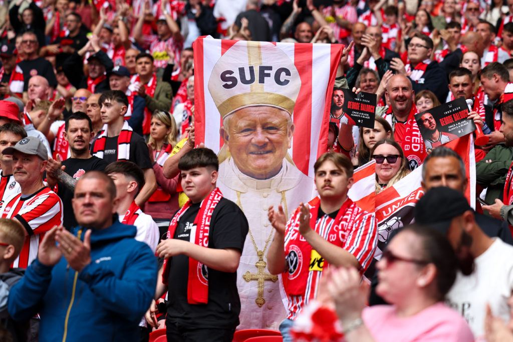 Sheffield United fans hold up a flag of Chris Wilder dressed up as the Pope