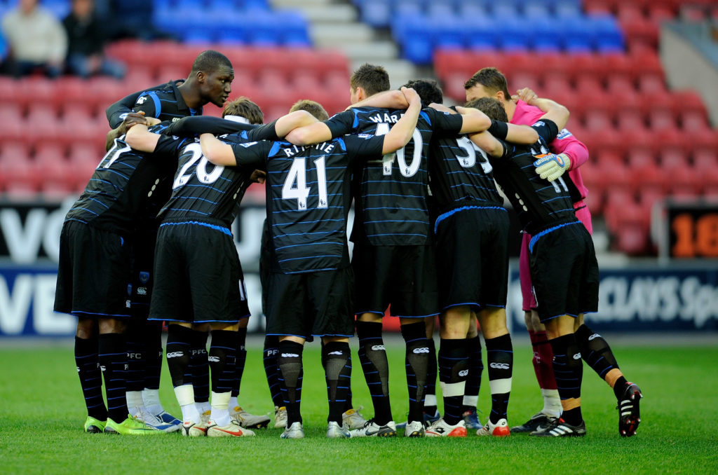 Papa Bouba Diop of Portsmouth talks to team mates before the Barclays Premier League match between Wigan Athletic and Portsmouth