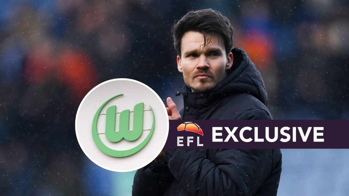 Danny Rohl watches on in the rain during Sheffield Wednesday's Championship game, a detailed view of the Wolfsburg club badge