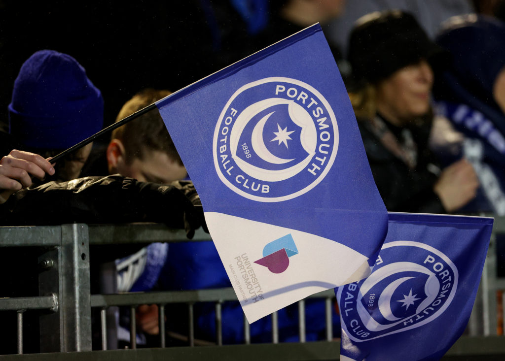 Fans holding a flag with Portsmouth badge