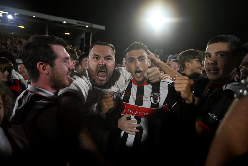 Jaze Kabia of Grimsby Town celebrates victory with fans