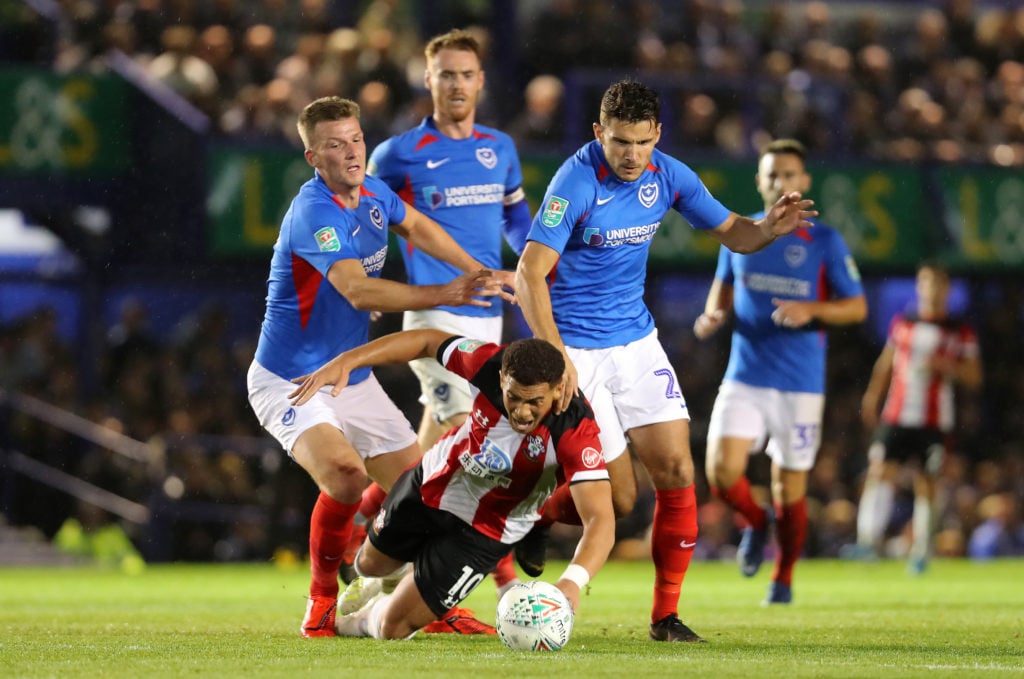 Che Adams of Southampton is fouled by Paul Downing and Gareth Evans of Portsmouth FC