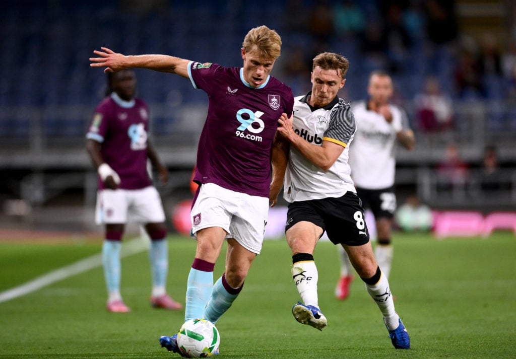 Zian Flemming of Burnley is challenged by Ben Osborn of Derby County during the Carabao Cup Second Round match between Burnley and Derby County