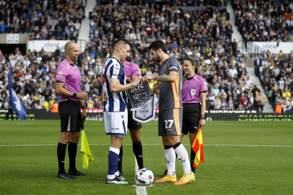 Captains Jed Wallace of West Bromwich Albion and Lewis Travis of Derby County exchange commemorative pennants to mark the 125th anniversary of the Hawthorns