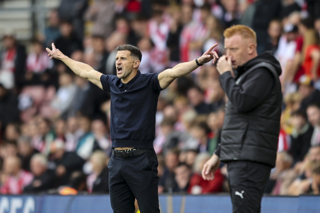 John Mousinho stretches his arms out in protest on the touch line at Southampton as Will Still stands in the foreground looking on at the game against Portsmouth